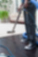 A person cleaning a light-coloured carpet with a carpet cleaner