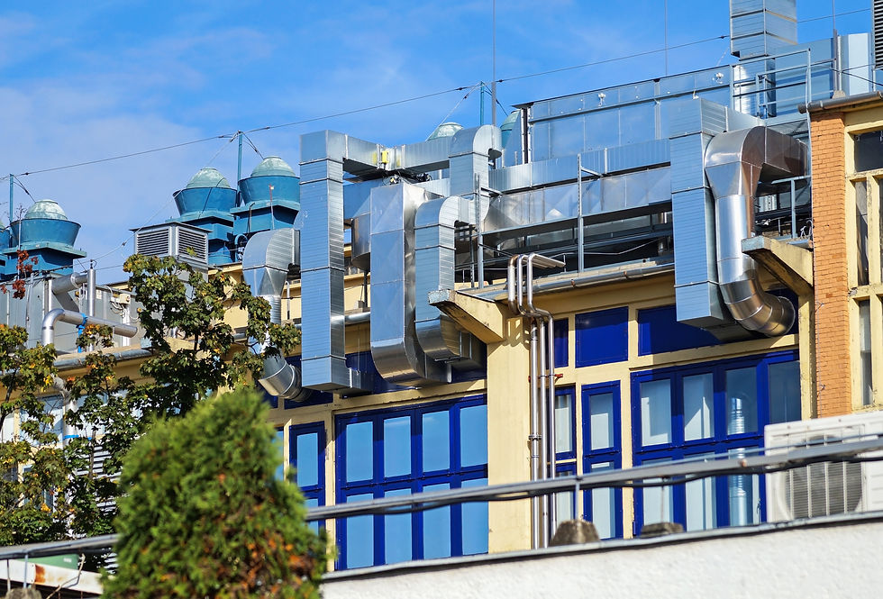Industrial rooftop with gleaming metallic vents and ducts above a building