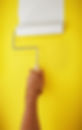 Paint roller on a yellow wall