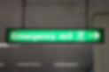 Emergency exit lighted green sign in an airport
