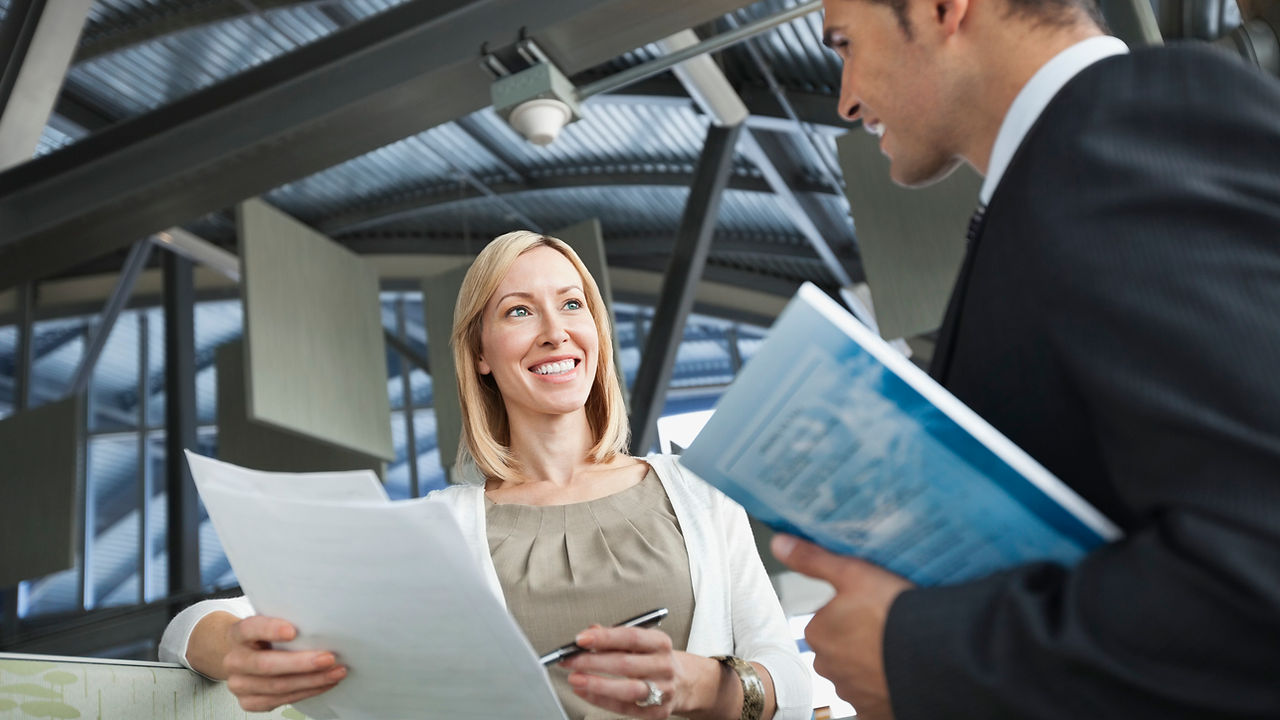 Businesswoman reviewing paperwork with colleague