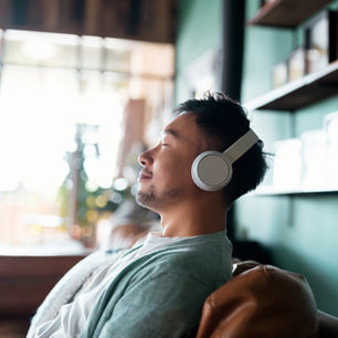 Mann hört entspannt Musik mit Kopfhörern