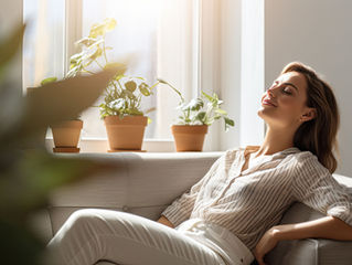 woman in chair by a window smiling as the sun shines on her face