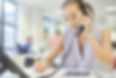 A woman in a modern office speaking with a client on the phone