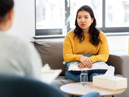 Woman on therapist couch in yellow sweater. Therapy office in Doylestown, PA offering ART and EMDR trauma therapy.
