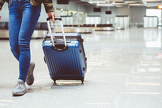 Traveller wheeling suitcase through an airport terminal for executive transfers