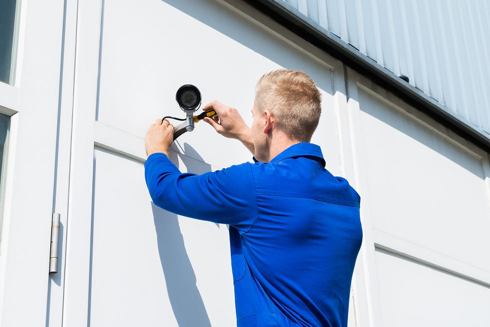 Engineer installing outdoor CCTV security camera on wall