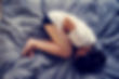 Woman curled on bed