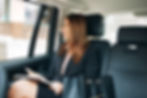 A businesswoman looking thoughtfully of the window of a car
