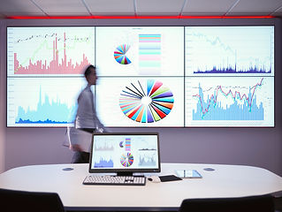 A modern conference room with multiple data charts on the screen