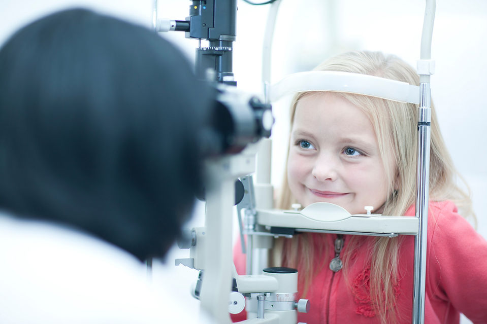Close-up of optician monitoring young girl in eye clinic
