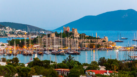 View of a Mediterranean marina with sailboats tied along pontoons