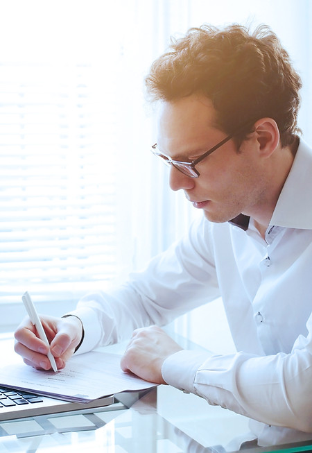 Man sitting at desk writing notes