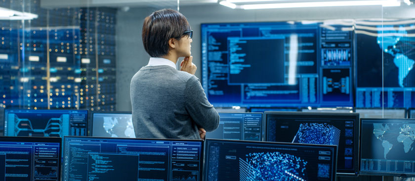 man in a data center glancing at monitors