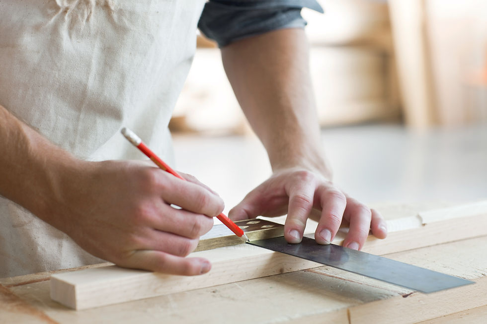 close-up image of carpenter's hand while using pencil and measuring tool