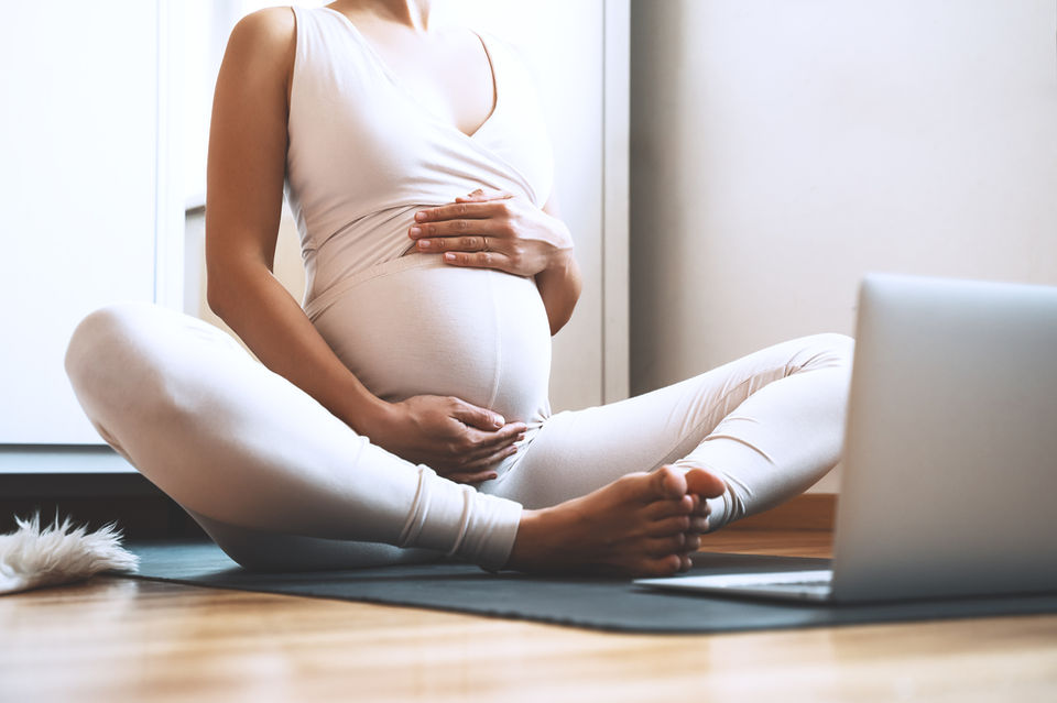 Maternity Photography by Blake Ferguson depicts a woman holding her Baby Bump while participating in at-home activities in Ontario, Canada.