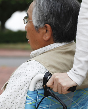 elderly man being pushed in a wheelchair