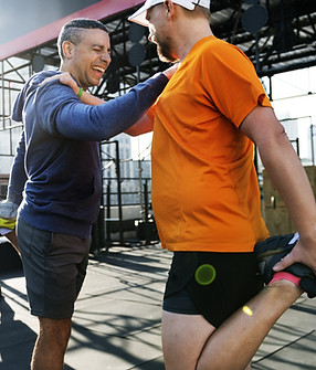 Two people stretching after workout and smiling