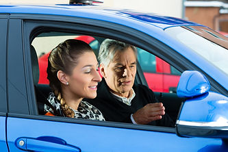 Young woman steers car, possibly during driving test or practice