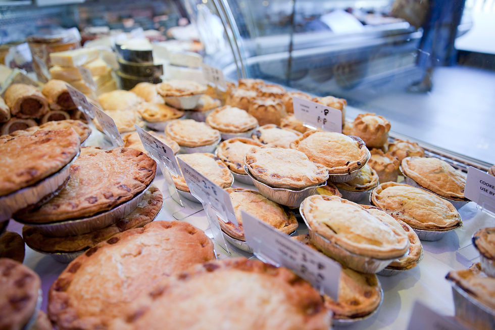 Assorted savory pies with price labels displayed in a bakery counter