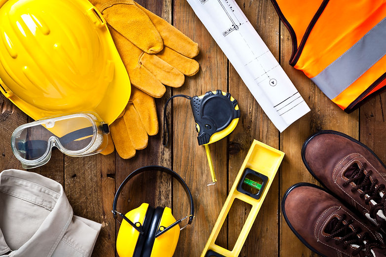 Personal protective workwear and blueprint with some measuring instruments shot directly f
