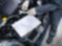 Mechanic's hands holding tool and inspecting car engine