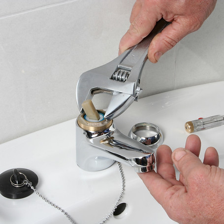 Plumber repairing the faucet of a sink