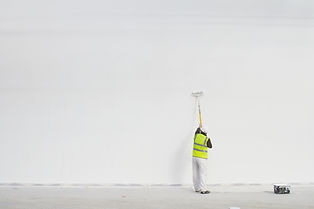 Worker painting on site, exterior and interior