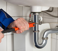 Plombier réparant une canalisation