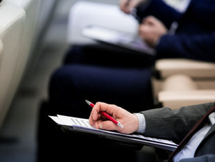 Una persona tomando notas en una reunión