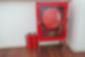 Red fire hose cabinet with hose and two extinguishers