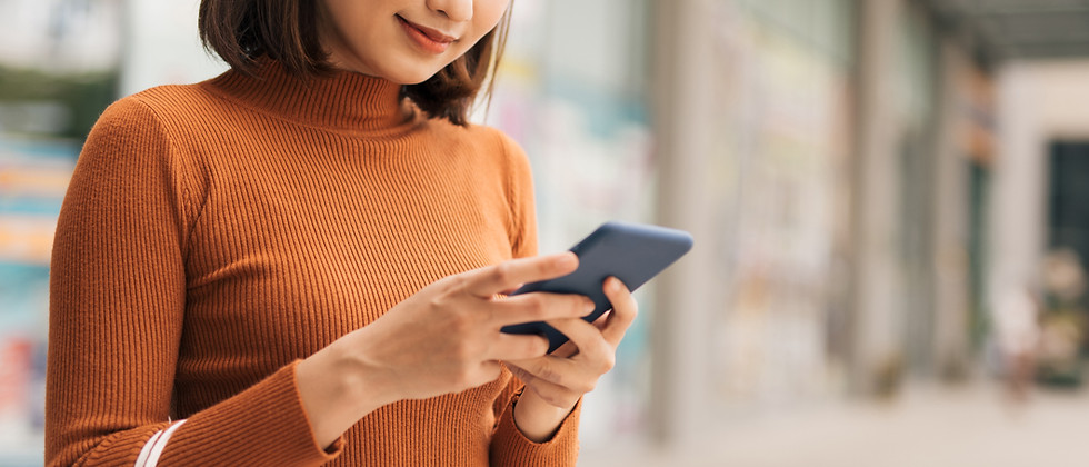 Asian woman checking her smartphone while shopping