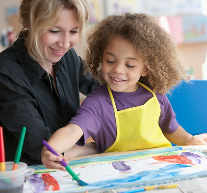 childcare provider teaching girl art