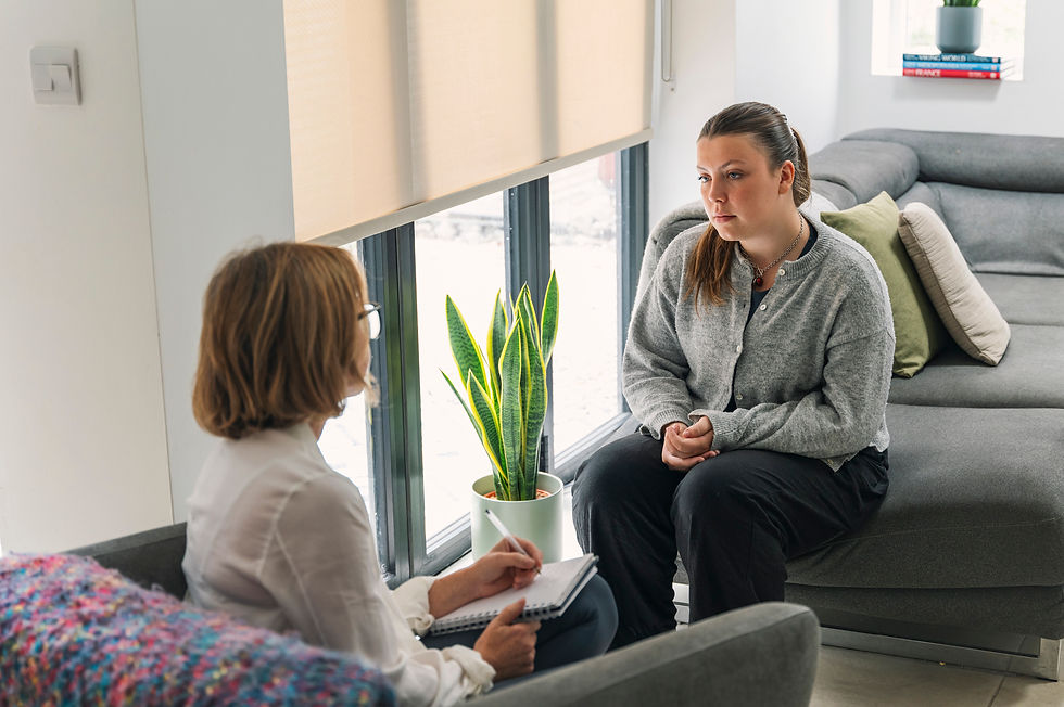 Young woman with mental health issues sits on sofa and talks to her therapist