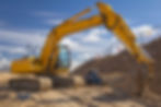Yellow Excavator in a new road construction against blue sky
