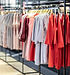 Roupas exibidas em prateleiras dentro de uma loja