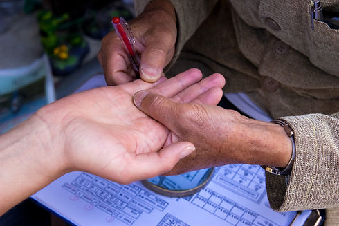 Reader using a red tool to trace lines on an open palm