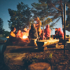 Kamp ateşi ile oturuyor