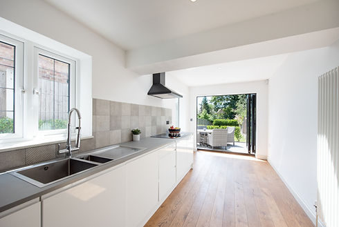 A bright, modern kitchen features white cabinetry
