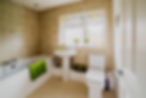 Bright bathroom with beige tile walls and a window