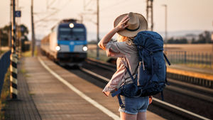 A tourist with a backpack waiting for a train