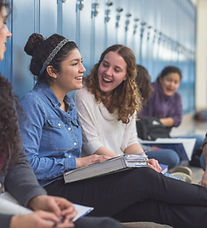 Skolelever i sitter på golvet i korridoren