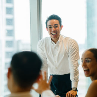 A man standing and smiling in front of the meeting room