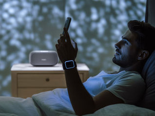 A man in bed looking at his phone