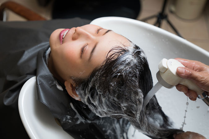 Hairdresser washing a woman's head at a hair salon