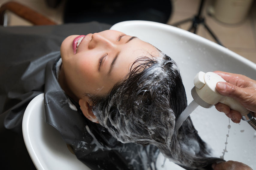 Hairdresser washing a woman's head at a hair salon