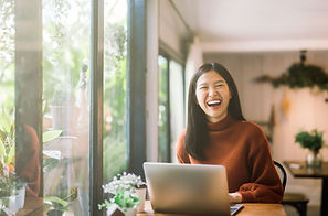 A woman smile in front of a laptop PC