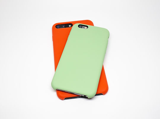 Close-Up Of Mobile Phones With Covers Over White Background
