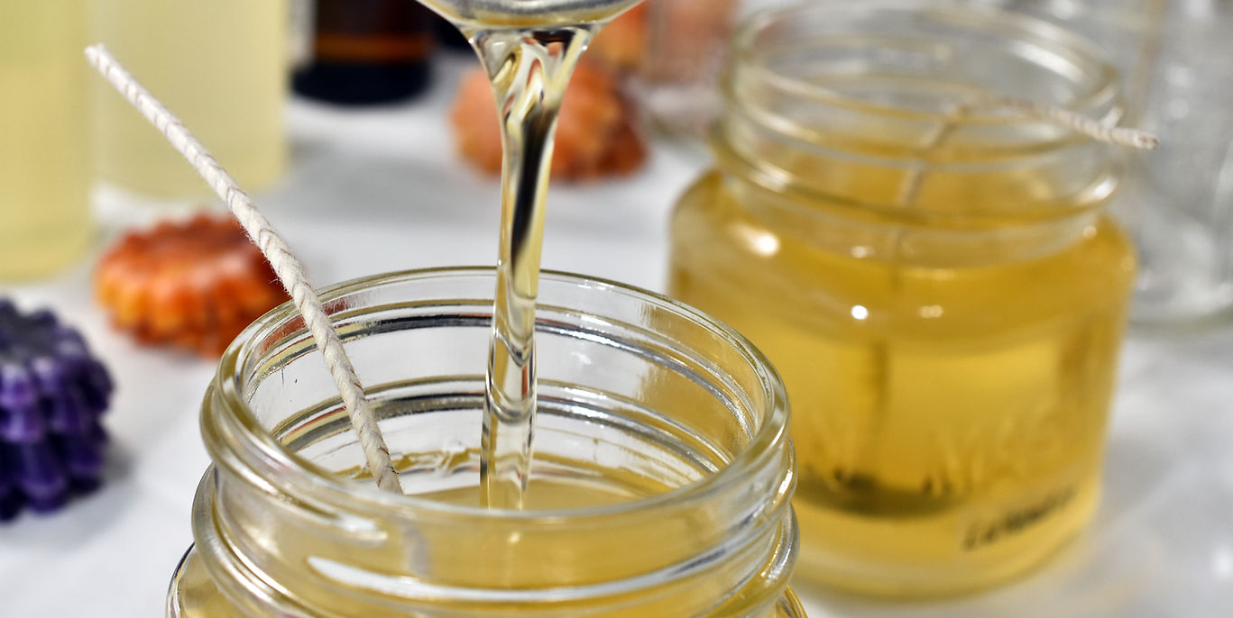 Photo of pouring wax in candle jar at a crafting table, illustrating a candle-making activity. Ideal for showcasing a