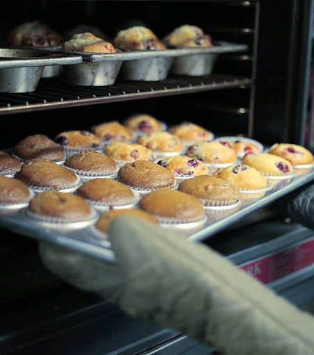 Muffins being taken out of an oven